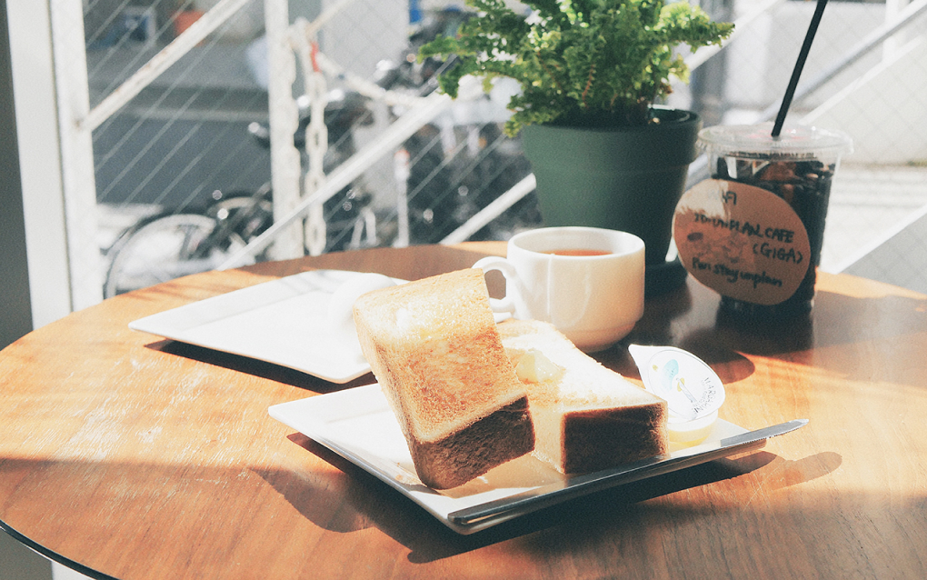 カフェのテーブルにトーストとコーヒーが置かれている