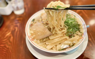 橋で麺を掬っているラーメンの写真